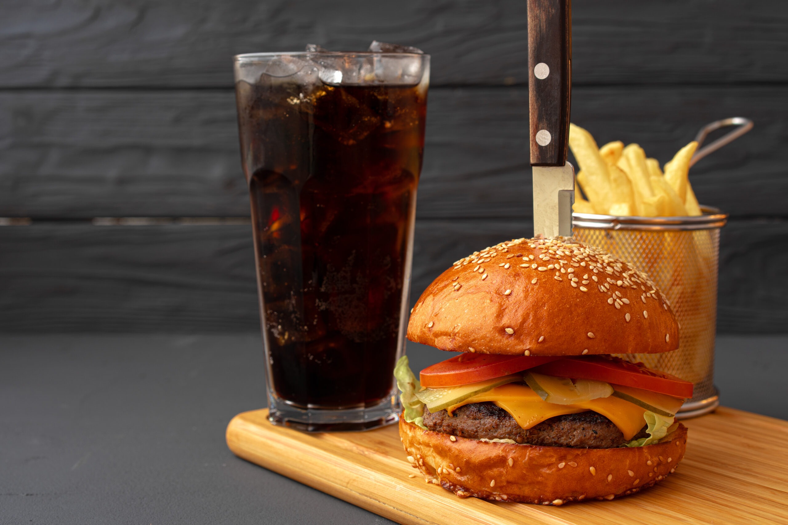 Tasty burger on black wooden background close up
